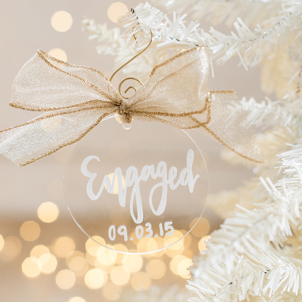 custom hand lettered engaged with date acrylic ornament perfect to gift to bride and groom for christmas or at an engagement party.